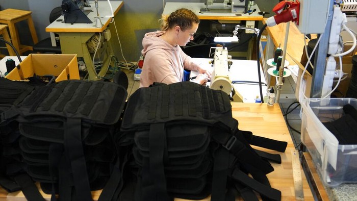 Melihat Pembuatan Rompi Anti Peluru untuk Relawan Ukraina A Ukrainian worker carries newly produced body armor at a leatherwork shop in Prague, Czech Republic, Thursday, April 21, 2022. A Czech leatherwork company that makes a wide variety of handmade products β travel bags, wallets and belts β never intended to add personal protective gear that would save lives in a war to its offerings. But the Russian invasion of Ukraine has changed all that. After Russian troops launched their assault, Tlusty & Co. has hired 15 Ukrainian refuges to help it manufacture body armor for Ukraine's volunteer defenders. (AP Photo/Petr David Josek)
