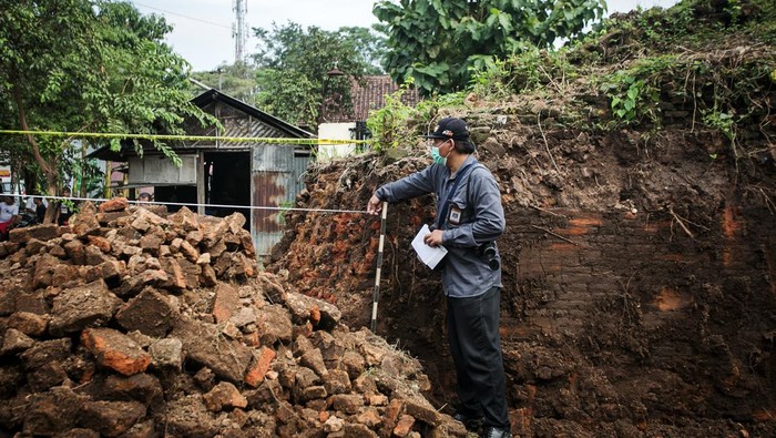 Warga duduk di depan alat berat yang digunakan untuk menjebol tembok benteng Keraton Kartasura di Sukoharjo, Jawa Tengah, Sabtu (23/4/2022). Benda cagar budaya (BCB) peninggalan Keraton Kartasura tersebut dirobohkan pemilik lahan dengan alat berat dan akan dimanfaatkan sebagai lokasi usaha dan kasus tersebut masih dalam penyelidikan Kepolisian dan BPCB Jawa Tengah. ANTARA FOTO/Mohammad Ayudha/aww.