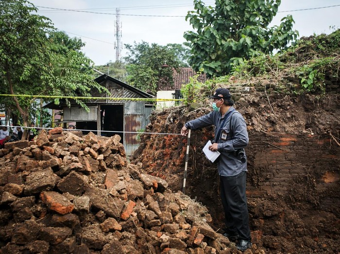 Warga duduk di depan alat berat yang digunakan untuk menjebol tembok benteng Keraton Kartasura di Sukoharjo, Jawa Tengah, Sabtu (23/4/2022). Benda cagar budaya (BCB) peninggalan Keraton Kartasura tersebut dirobohkan pemilik lahan dengan alat berat dan akan dimanfaatkan sebagai lokasi usaha dan kasus tersebut masih dalam penyelidikan Kepolisian dan BPCB Jawa Tengah. ANTARA FOTO/Mohammad Ayudha/aww.