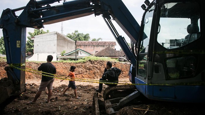 Warga duduk di depan alat berat yang digunakan untuk menjebol tembok benteng Keraton Kartasura di Sukoharjo, Jawa Tengah, Sabtu (23/4/2022). Benda cagar budaya (BCB) peninggalan Keraton Kartasura tersebut dirobohkan pemilik lahan dengan alat berat dan akan dimanfaatkan sebagai lokasi usaha dan kasus tersebut masih dalam penyelidikan Kepolisian dan BPCB Jawa Tengah. ANTARA FOTO/Mohammad Ayudha/aww.