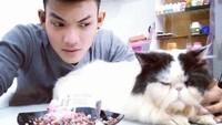Pecinta hewan terutama kucing, sosok Tri yang masih muda tampil imut saat makan es krim dengan topping meises aneka warna sambil ditemani kucing putih yang menggemaskan. Foto: Instagram @xdjtrisuaka