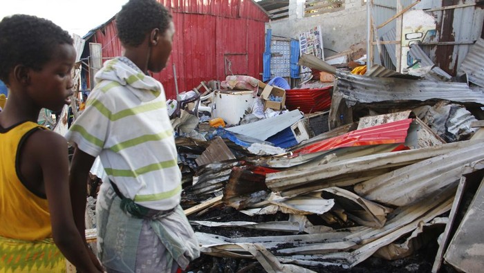 People look at destroyed shops in Mogadishu's Lido beach, Somalia, Saturday, April, 23, 2022, after a bomb blast by Somalia’s Islamic extremist rebels hit a popular seaside restaurant killing at least six people. Ambulance service officials say the explosion occurred Friday evening when many patrons gathered for an Iftar meal to break the Ramadan fast. (AP Photo/Farah Abdi Warsameh)