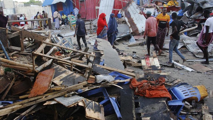 People look at destroyed shops in Mogadishu's Lido beach, Somalia, Saturday, April, 23, 2022, after a bomb blast by Somalia’s Islamic extremist rebels hit a popular seaside restaurant killing at least six people. Ambulance service officials say the explosion occurred Friday evening when many patrons gathered for an Iftar meal to break the Ramadan fast. (AP Photo/Farah Abdi Warsameh)