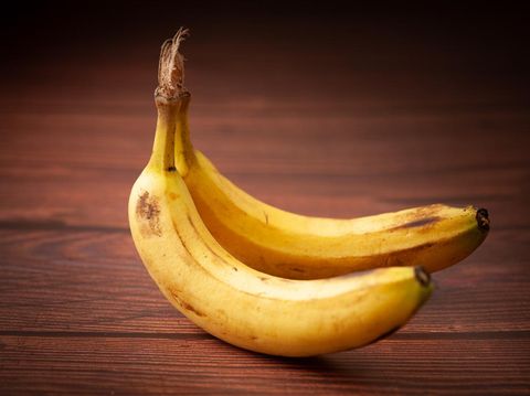 Close-up of two ripe banana (Musa sp) fruits over the wooden background.