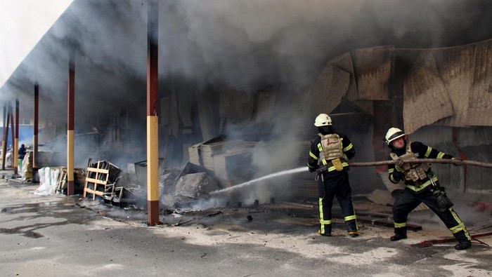 A firefighter runs as he participates in efforts to extinguish a fire that broke out in a steel warehouse following a military strike, amid Russia's invasion of Ukraine, in Kharkiv, Ukraine, April 23, 2022. REUTERS/Oleksandr Lapshyn