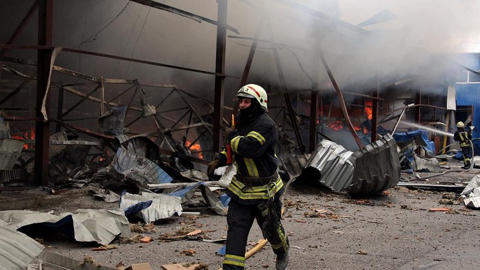 A firefighter runs as he participates in efforts to extinguish a fire that broke out in a steel warehouse following a military strike, amid Russia's invasion of Ukraine, in Kharkiv, Ukraine, April 23, 2022. REUTERS/Oleksandr Lapshyn