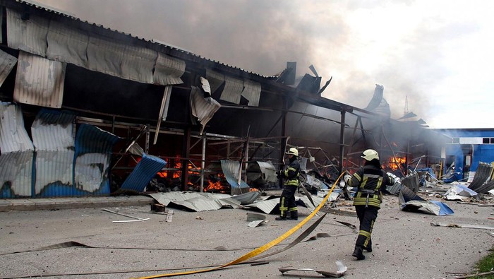 A firefighter runs as he participates in efforts to extinguish a fire that broke out in a steel warehouse following a military strike, amid Russia's invasion of Ukraine, in Kharkiv, Ukraine, April 23, 2022. REUTERS/Oleksandr Lapshyn