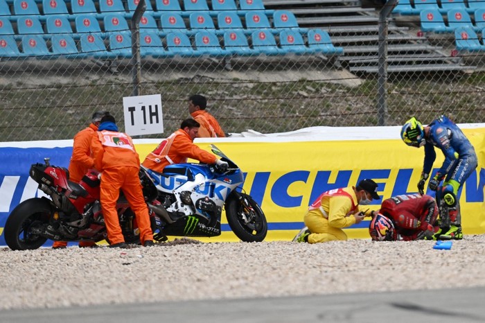 Suzuki Spanish rider Joan Mir (R) checks on Ducati Australian rider Jack Miller after both crashed during the MotoGP Portuguese Grand Prix at the Algarve International Circuit in Portimao on April 24, 2022. (Photo by PATRICIA DE MELO MOREIRA / AFP)