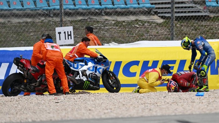 Suzuki Spanish rider Joan Mir (R) checks on Ducati Australian rider Jack Miller after both crashed during the MotoGP Portuguese Grand Prix at the Algarve International Circuit in Portimao on April 24, 2022. (Photo by PATRICIA DE MELO MOREIRA / AFP)