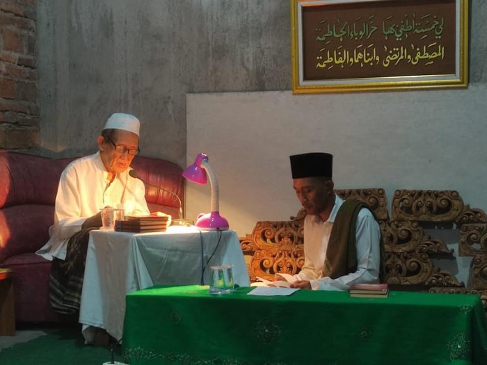 Mbah Kiai Sanusi Yasin di kediamannya kompleks Pondok Pesantren Budaya Bumi Wangi, Jekulo sedang membaca Kitab Dalail Khairat bersama putranya Gus Kholid. Foto diupload pada Minggu (24/4/2022).