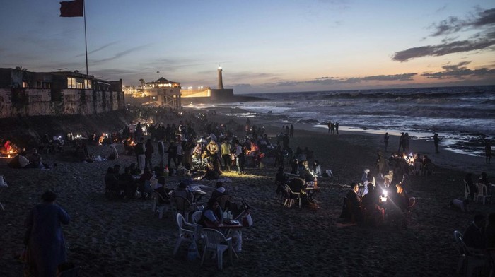 Menanti Waktu Berbuka Puasa di Tepi Pantai Rabat Maroko A family pose for a photo as they break their Ramadan fast by the beach in Rabat, Morocco, Saturday, April 23, 2022. For the first time in two years since the COVID-19 pandemic, people were able to revive a Ramadan tradition of gathering and breaking their fast in public. (AP Photo/Mosa'ab Elshamy)