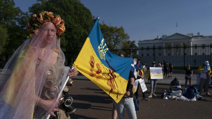 Pakai Gaun Pengantin, Wanita Ini Aksi Dukung Ukraina A demonstrator dressed in a wedding dress with gas-masks participates in a protest in solidarity with Ukraine outside the White House in Washington, Saturday, April 23, 2022. (AP Photo/Gemunu Amarasinghe)