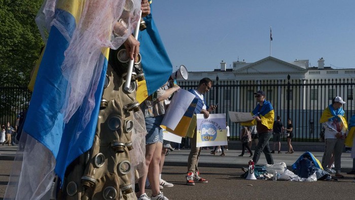 A demonstrator dressed in a wedding dress with gas-masks participates in a protest in solidarity with Ukraine outside the White House in Washington, Saturday, April 23, 2022. (AP Photo/Gemunu Amarasinghe)