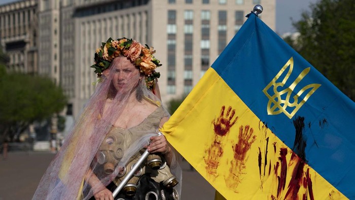 Pakai Gaun Pengantin, Wanita Ini Aksi Dukung Ukraina A demonstrator dressed in a wedding dress with gas-masks participates in a protest in solidarity with Ukraine outside the White House in Washington, Saturday, April 23, 2022. (AP Photo/Gemunu Amarasinghe)