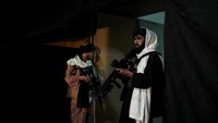 Pejuang Taliban berjaga di lokasi acara dengan menenteng senjata.