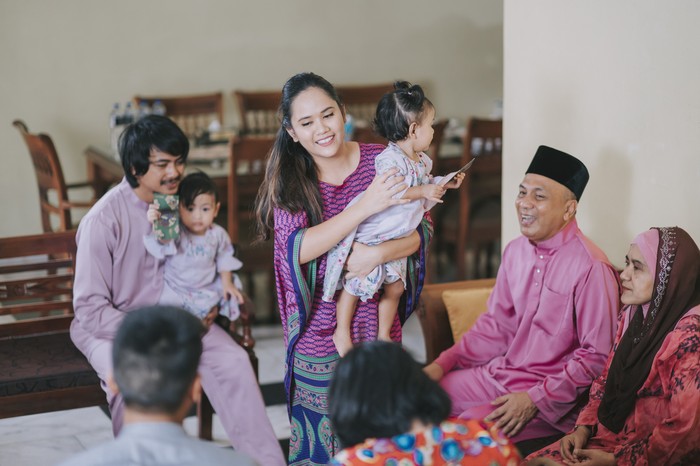 Hari raya malay muslim family in traditional clothing bonding family reunion on Hari Raya Aidilfitri / Eid-Ul-Fitr celebration in living room
