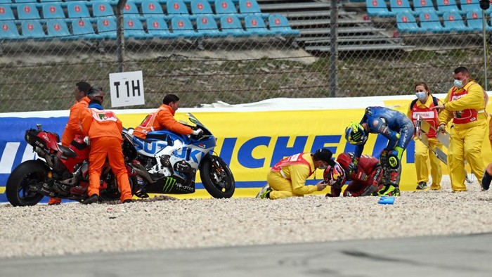 Suzuki Spanish rider Joan Mir (R) checks on Ducati Australian rider Jack Miller after crashing during the MotoGP Portuguese Grand Prix at the Algarve International Circuit in Portimao on April 24, 2022. (Photo by PATRICIA DE MELO MOREIRA / AFP)