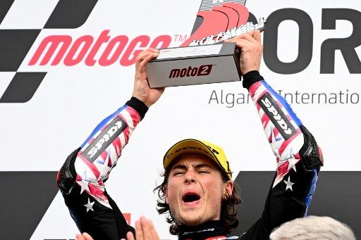 Kalex Italtrans Racing Team US rider Joe Roberts celebrates on the podium after the Moto2 race of the Portuguese Grand Prix at the Algarve International Circuit in Portimao on April 24, 2022. (Photo by GABRIEL BOUYS / AFP)
