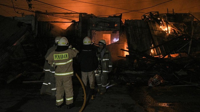 Momen Pasar Gembrong Jaktim Hangus Dilalap Si Jago Merah Seorang warga dan petugas memadamkan api yang membakar kios dan rumah di pasar Gembrong, Jatinegara, Jakarta Timur, Minggu (24/4/2022). Pemadam kebakaran mengerahkan 14 unit mobil dalam peristiwa itu. ANTARA FOTO/ Fakhri Hermansyah/pras.