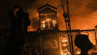 Sejumlah warga mengamati kios dan rumah yang terbakar di pasar Gembrong, Jatinegara, Jakarta Timur, Minggu (24/4/2022).  