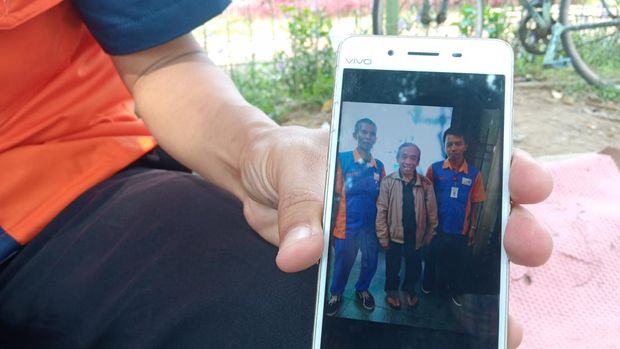 Porter di Stasiun Bekasi, Dodi, menunjukkan foto dirinya berfoto bersama pelawak Haji Qomar (Fakhri/detikcom)