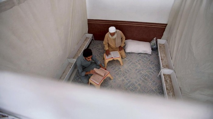 A Muslim worshipper recites from the Quran in his section while he observes 