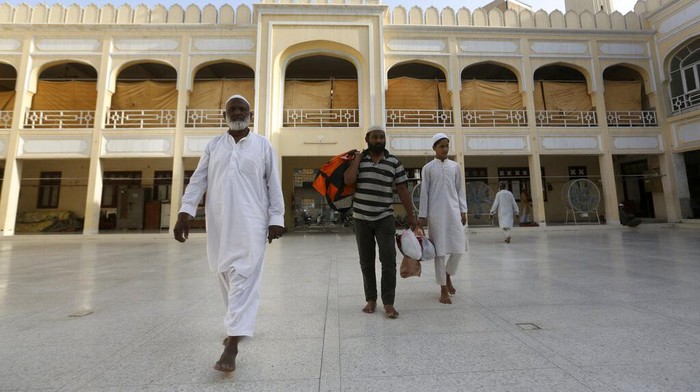 A Muslim worshipper recites from the Quran in his section while he observes 