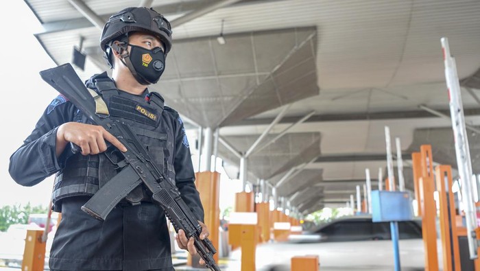 Bawa Senjata Laras Panjang, Brimob Jaga Gerbang Tol Palimanan Dua personel Satbrimob Polda Jawa Barat berjaga di Gerbang Tol Palimanan, Cirebon, Jawa Barat, Selasa (26/4/2022). Personel Satbrimob Polda Jawa Barat berjaga di sejumlah ruas jalan tol Trans Jawa untuk memberi kemananan dan kenyamanan pemudik selama arus mudik dan arus balik 2022. ANTARA FOTO/M Risyal Hidayat/aww.