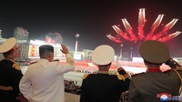 Kim Jong Un bersama sejumlah pejabat tinggi Korea Utara menyaksikan atraksi pesawat saat tengah melakukan pertunjukan udara di tengah gelaran parade militer untuk untuk menandai peringatan 90 tahun berdirinya Tentara Revolusioner Rakyat Korea di Pyongyang, Korea Utara.
