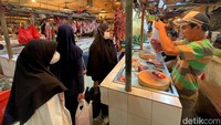 Tampak pedagang memasukkan potongan daging sapi yang dibeli warga ke kantung plastik di Pasar Senen, Jakarta.