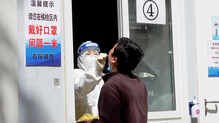 Jutaan Warga Beijing Mulai Lakukan Tes Covid-19 Massal People line up outside a makeshift nucleic acid testing site during a mass testing for the coronavirus disease (COVID-19) in Haidian district of Beijing, China April 26, 2022. REUTERS/Carlos Garcia Rawlins