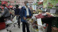 Sejumlah warga mendorong troli berisi beragam kebutuhan pokok saat berbelanja di salah satu supermarket yang berada di kawasan Beijing, China, Senin (25/4/2022). (AP Photo/Ng Han Guan).