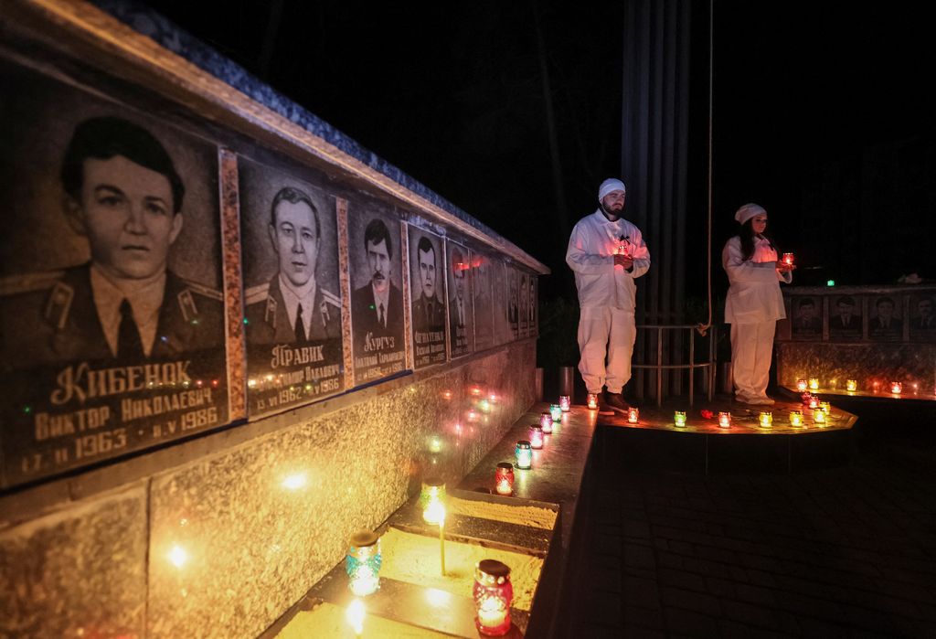 A staff of the Chornobyl nuclear plant holds a candle as he visits a memorial dedicated to firefighters and workers who died after the Chornobyl nuclear disaster, during a night service, amid Russia's invasion of Ukraine, in Slavutych, Ukraine April 26, 2022.  REUTERS/Gleb Garanich
