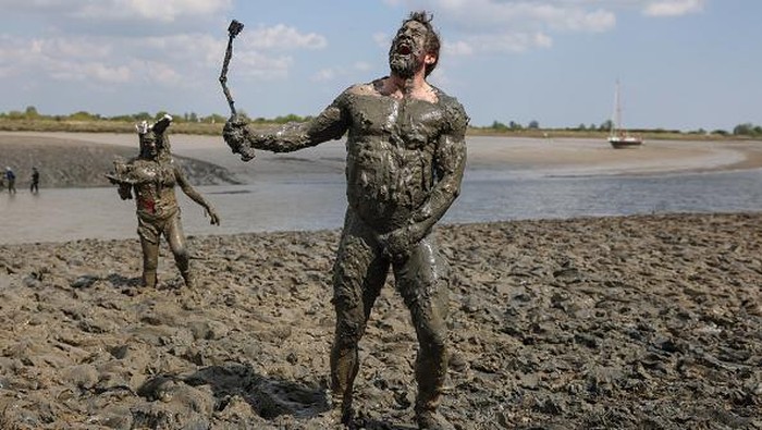 Saat Joker dan Batman Seru-seruan Ikut Balap Lumpur di Inggris MALDON, ENGLAND - APRIL 24: Competitors dressed as Batman characters participate in the Maldon Mud Race on April 24, 2022 in Essex, England. The annual race resumed after two years' hiatus due to Covid-19. (Photo by Hollie Adams/Getty Images)