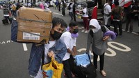 Kembali diizinkannya mudik di momen lebaran membuat sejumlah pihak kembali mengadakan kegiatan mudik gratis yang disambut antusias oleh masyarakat. Pemudik berdatangan ke lokasi keberangkatan untuk menunggu bus yang akan mengantar mereka ke kampung halaman di Jawa Tengah dalam perjalanan mudik gratis yang disponsori Kementerian BUMN di Jakarta, Rabu (27/4/2022). (AP Photo/Dita Alangkara).