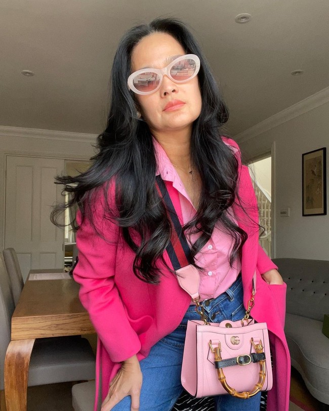 Donna Harun tampak semakin awet muda ketika memadukan jubah pink tersebut dengan kemeja pink dan jeans. Gayanya semakin maksimal ketika menambahkan tas Gucci yang juga berwarna merah muda. Foto: Instagram @donnaharunofficial