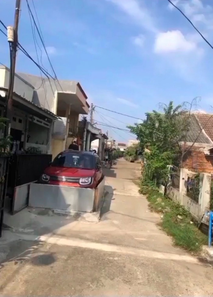 mobil parkir di depan rumah dengan pembatas