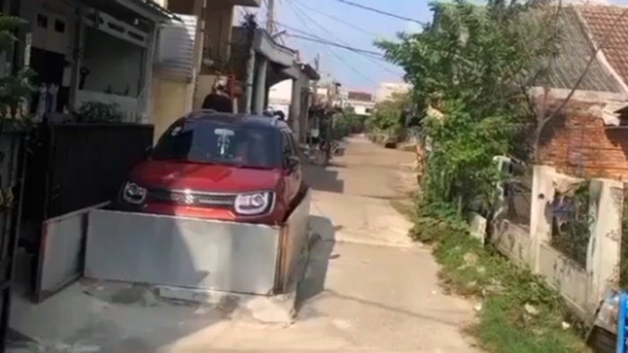 mobil parkir di depan rumah dengan pembatas