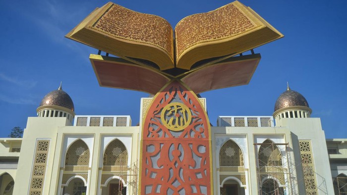 Warga duduk di belakang monumen Al Quran kawasan Islamic Center Kota Padang Panjang, Sumatera Barat, Rabu (24/7/2022). Monumen Al Quran tersebut merupakan ikon baru Padang Panjang sebagai Kota Serambi Mekkah yang dibangun oleh alumni angkatan 81 SMP se-kota itu. ANTARA FOTO/Iggoy el Fitra/rwa.