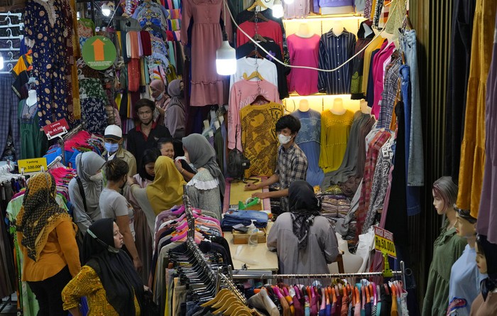 Pemburu Baju Baru Berjubelan di Pasar Jatinegara People shop for new clothes during the last week of Ramadan at a market in Jakarta, Indonesia, Tuesday, April 26, 2022. People flock to markets and shopping malls in the capital city as they shop for food and new clothings in preparation for Eid al Fitr holiday next week marking the end of the holiest month in Islamic calendar. (AP Photo/Tatan Syuflana)