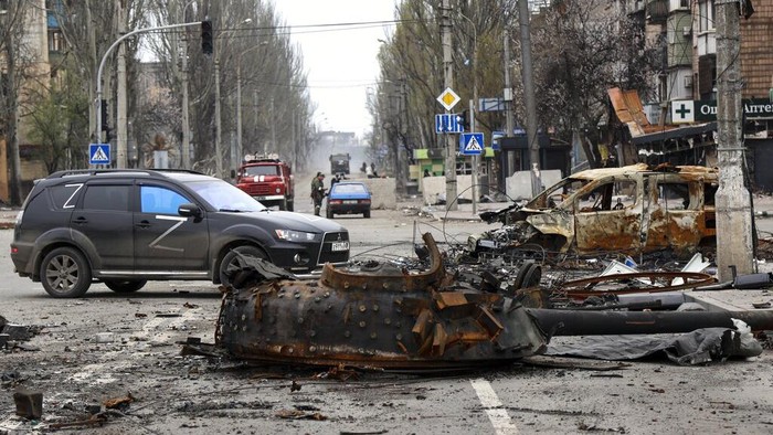 Damaged and burned vehicles are seen at a destroyed part of the Illich Iron & Steel Works Metallurgical Plant, as smoke rises from the Metallurgical Combine Azovstal during heavy fighting, in an area controlled by Russian-backed separatist forces in Mariupol, Ukraine, Monday, April 18, 2022. (AP Photo/Alexei Alexandrov, File)