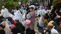 Seorang muslimah ikut mengaji sambil menggendong Balitanya.