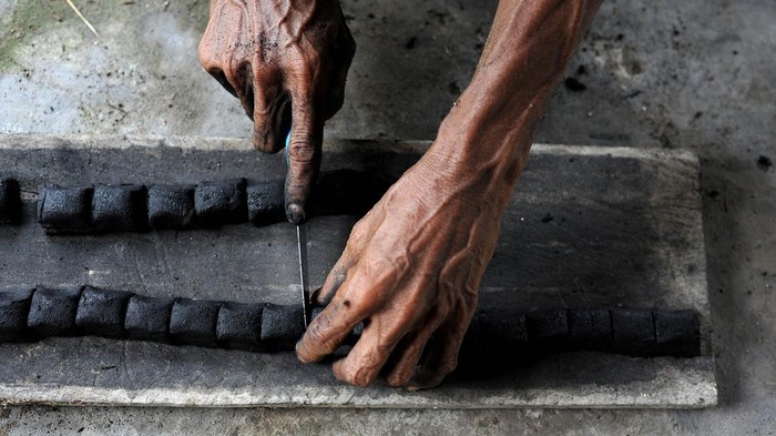 PRODUKSI BRIKET PELEPAH PINANG Perajin menjemur bahan baku briket dari limbah pelepah pinang saat proses produksi di sentra perkebunan pinang Suak Rengas, Desa Teluk Kulbi, Betara, Tanjungjabung Barat, Jambi, Senin (25/4/2022). Briket yang diproduksi secara tradisional dengan memanfaatkan limbah pelepah pinang oleh beberapa warga yang tergabung dalam Kelompok Tani Rengas Lestari tersebut dijual Rp20 ribu per kilogram. ANTARA FOTO/Wahdi Septiawan/YU