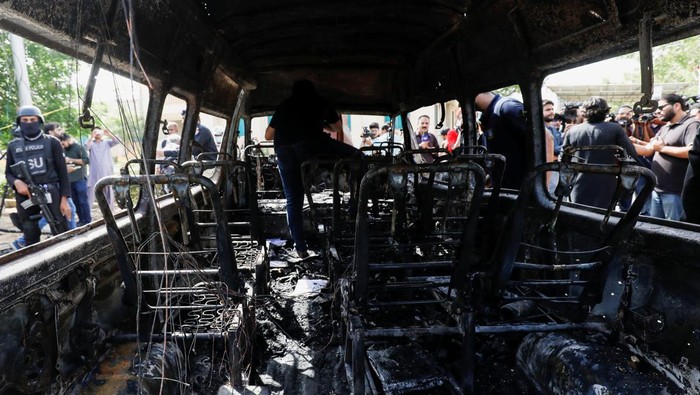 Sisa-sisa Bom Bunuh Diri yang Tewaskan 4 Orang di Pakistan Police officers stand guard near a passenger van, after a blast at the entrance of the Confucius Institute University of Karachi, Pakistan April 26, 2022. REUTERS/Akhtar Soomro