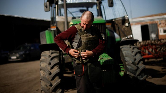 Oleksiy, a Ukrainian farmer, wearing body armour, works at the topsoil in a field, amid Russia's invasion of Ukraine, in Zaporizhzhia region, Ukraine April 26, 2022. REUTERS/Ueslei Marcelino