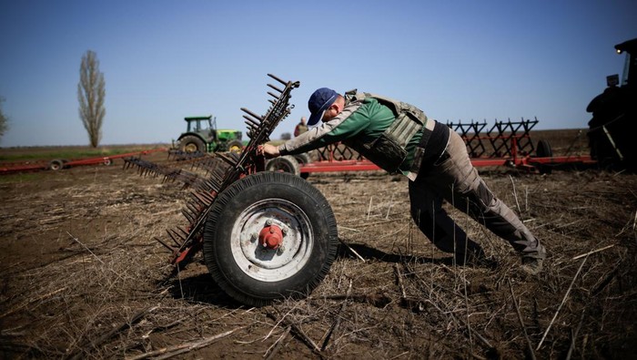 Oleksiy, a Ukrainian farmer, wearing body armour, works at the topsoil in a field, amid Russia's invasion of Ukraine, in Zaporizhzhia region, Ukraine April 26, 2022. REUTERS/Ueslei Marcelino