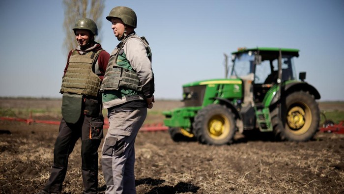 UKRAINE-CRISIS/FARMERS-BODY ARMOUR Oleksiy, a Ukrainian farmer, wearing body armour, works at the topsoil in a field, amid Russia's invasion of Ukraine, in Zaporizhzhia region, Ukraine April 26, 2022. REUTERS/Ueslei Marcelino