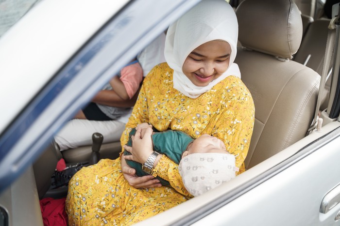 Little baby boy with her muslim mom inside car going for a trip