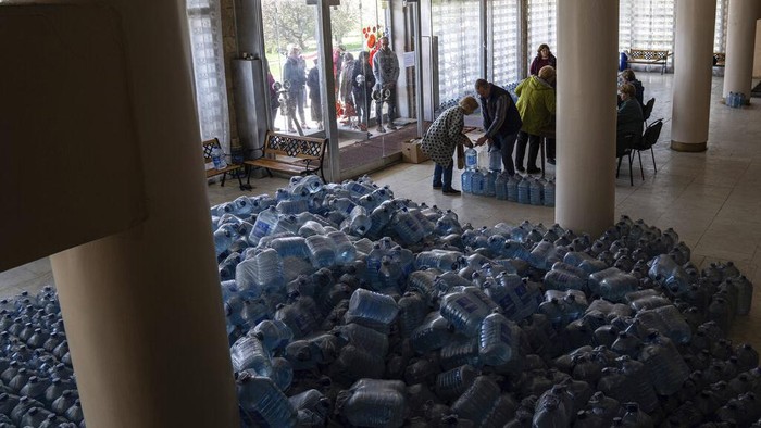 Imbas Perang, Kota di Ukraina Kini Krisis Air Local residents receive drinking water at a distribution centre in Toretsk, eastern Ukraine, Monday, April 25, 2022. Toretsk residents have had no access to water for more than two months because of the war. (AP Photo/Evgeniy Maloletka)