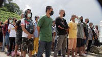 Sejumlah Pekerja Migran Indonesia (PMI) bermasalah berbaris di zona netral saat tiba di Pos Lintas Batas Negara (PLBN) Entikong di Kabupaten Sanggau, Kalimantan Barat, Kamis (28/4/2022).